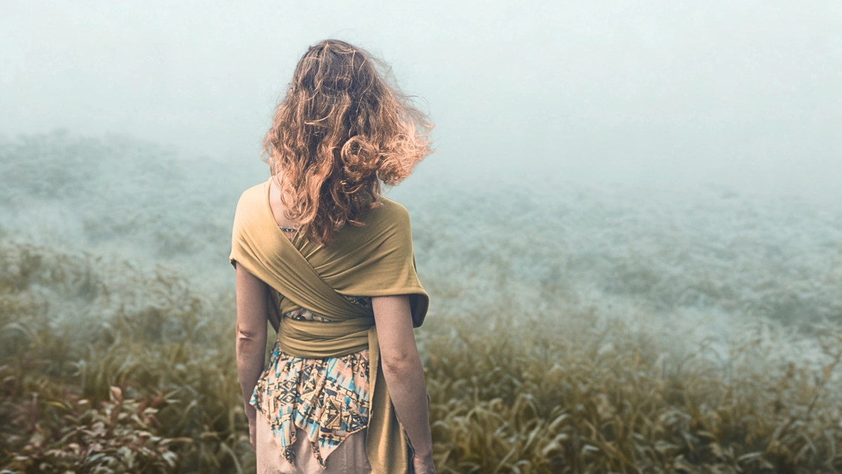 Mujer caminando entre la niebla representando la incertidumbre y la falta de claridad en la vida